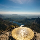 Trig point on top of Yr Wyddfa  (Snowdon) looking over the lakes.